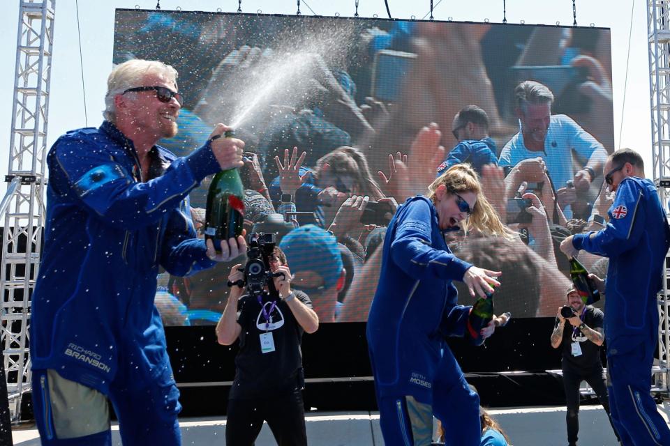 Richard Branson sprays the crew with champagne after completing their flight