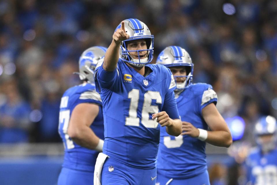 Lions quarterback Jared Goff (16) points to Jameson Williams after their 52-yard touchdown connection.