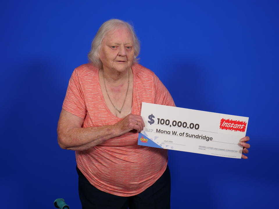 Grandmother holding a $100,000 lotto check. 