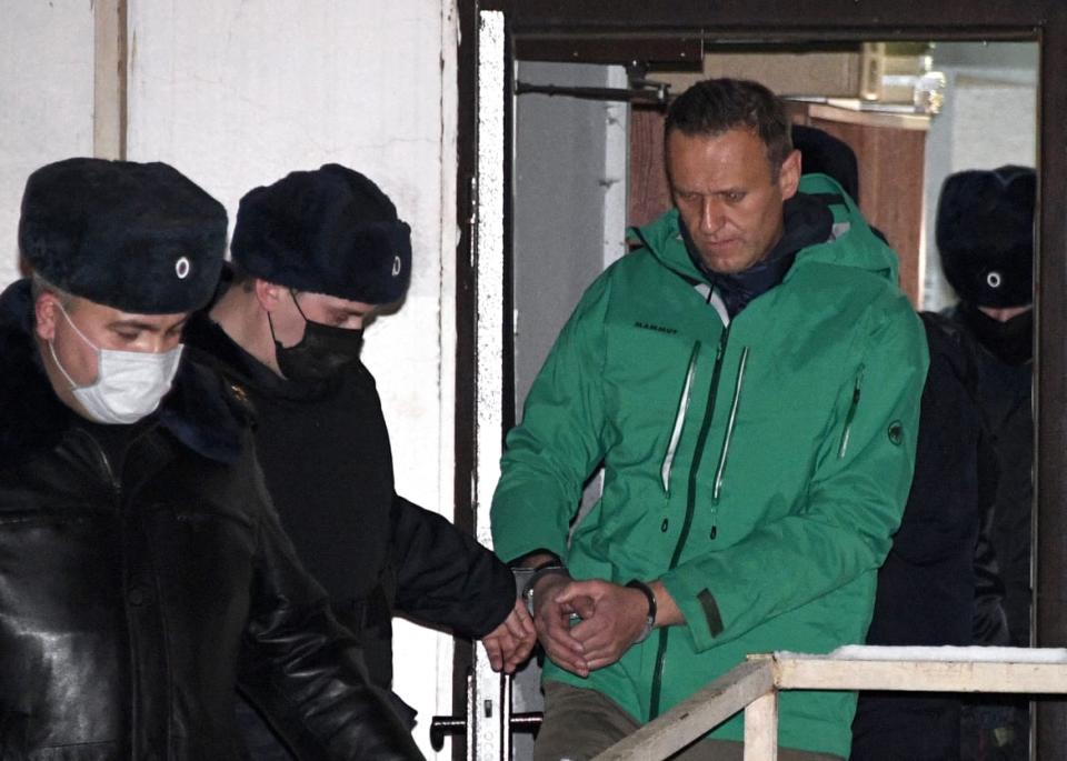 <div class="inline-image__caption"><p>Opposition leader Alexei Navalny is escorted out of a police station on Jan. 18, 2021, outside Moscow, following the court ruling that ordered him jailed for 30 days.</p></div> <div class="inline-image__credit">Alexander Nemenov/AFP via Getty Images</div>