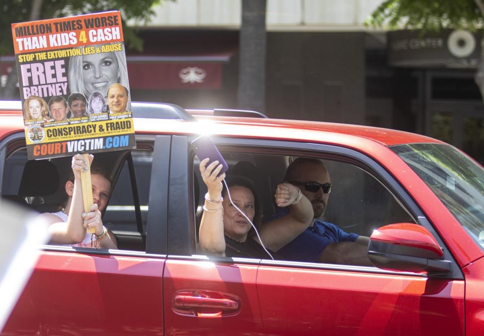 People drive past a Los Angeles courthouse holding signs and honking in support of Britney Spears on Wednesday.