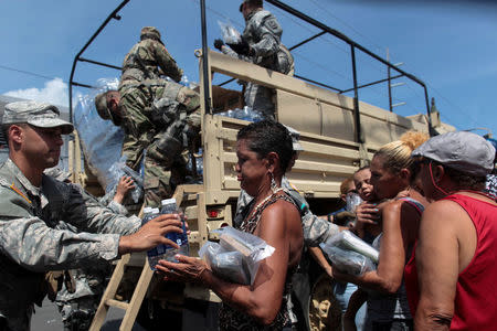 Soldiers of Puerto Rico's national guard distribute relief items to people, after the area was hit by Hurricane Maria in San Juan, Puerto Rico September 24, 2017. REUTERS/Alvin Baez