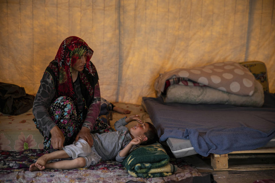 Halide comforts her son, who has temperature, inside the tent where the family temporarily live after a powerful quake in Kahramanmaras, southeastern Turkey, Monday, May 22, 2023. Two opposing visions for Turkey’s future are on the ballot when voters return to the polls Sunday for a runoff presidential election, which will decide between an increasingly authoritarian incumbent President Recep Tayyip Erdogan and challenger Kemal Kilicdaroglu, who has pledged to restore democracy. (AP Photo/Metin Yoksu)