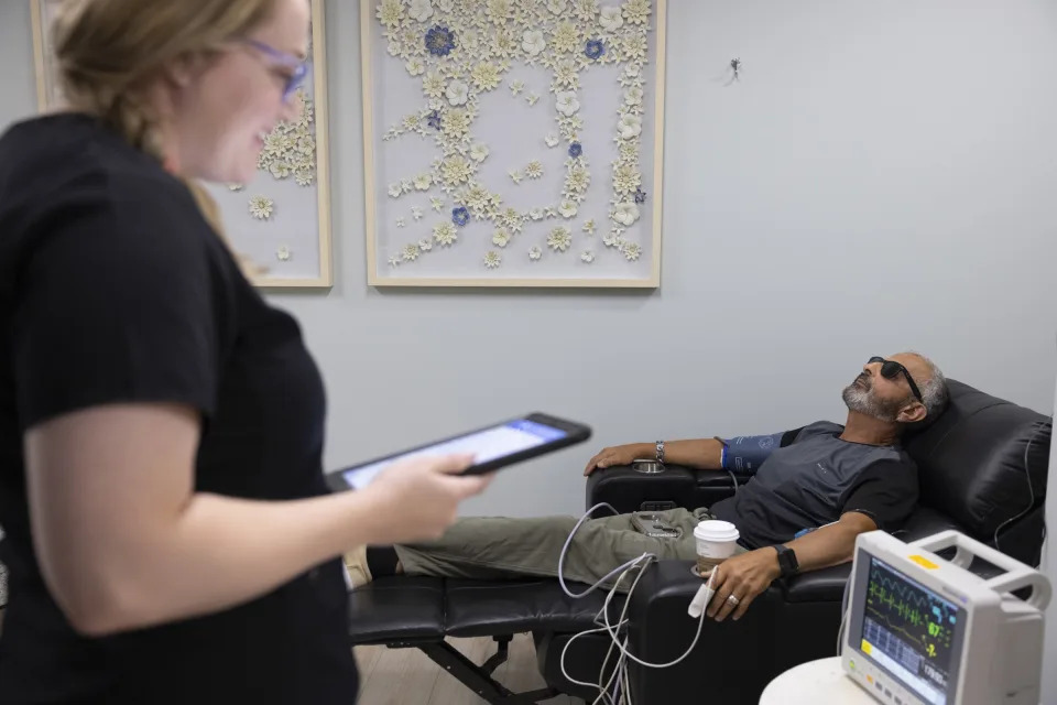 RICHMOND, VA - JULY 5:  Carl Montalbino, 67, receives his Ketamine treatment while nurse Melissa Dougher checks his vitals Tuesday, July 5, 2022 at MindPeace Clinic in Richmond, Virginia. Montalbino, who has suffered from depression since the age of 16, said the treatment is almost like a miracle. He wears sunglasses to subdue some of the visual effects of the drug. (Photo by Julia Rendleman for The Washington Post via Getty Images)