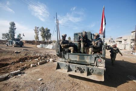 Iraqi rapid response forces ride in a military vehicle during a fight with Islamic State militants in Intisar district of eastern Mosul, Iraq, December 22, 2016. REUTERS/Khalid al Mousily/Files