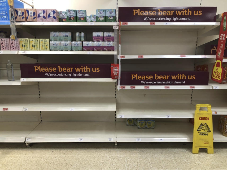 Empty shelves and signs on the soft drinks aisle of a Sainsbury's store in Rowley Regis in the West Midlands, England, Thursday July 22, 2021. Retailers in England warned Thursday of barren supermarket shelves as more and more staff get “pinged” on their phones to self-isolate because of contact with coronavirus cases. Grappling with staff shortages amid the so-called “pingdemic,” many businesses, such as supermarket chain Iceland, have had to close some stores. (Matthew Cooper/PA via AP)