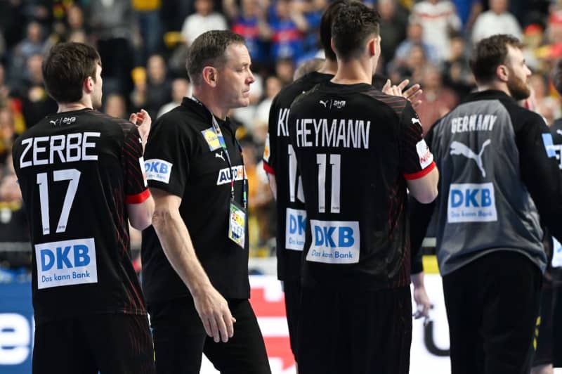 Germany's coach Alfred Gislason (2nd L) and his players react after the 2024 EHF European Men's Handball semi-finals match between Denmark and Germany at Lanxess Arena. Federico Gambarini/dpa