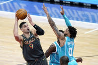 Chicago Bulls' Nikola Vucevic (9) shoots over Charlotte Hornets' Miles Bridges during the first half of an NBA basketball game Thursday, April 22, 2021, in Chicago. (AP Photo/Charles Rex Arbogast)