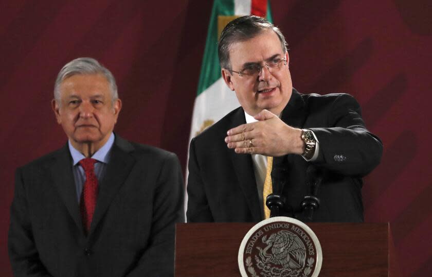 ARCHIVO - En esta fotografía de archivo del 12 de noviembre de 2019, el canciller mexicano Marcelo Ebrard responde preguntas de los periodistas durante la conferencia de prensa diaria del presidente Andrés Manuel López Obrador, de pie detrás de Ebrard, en el Palacio Nacional de la Ciudad de México. (AP Foto/Marco Ugarte, archivo)