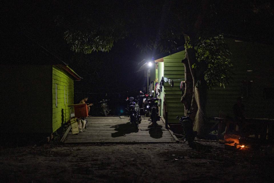 A man sits outside the dormitory for construction workers at the Kalimantan Industrial Park Indonesia (KIPI) in Kampung Baru village, North Kalimantan, Indonesia on Thursday, Aug. 24, 2023. The industrial park being built in Indonesia on the tropical island of Borneo that has attracted billions of dollars in foreign and domestic investment is damaging the environment in an area where endangered species live and migrate. (AP Photo/Yusuf Wahil)