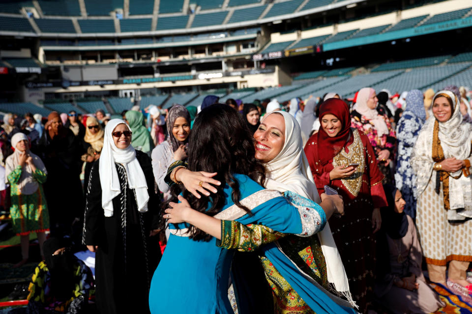 Muslim women hug as they gather for the celebration of the Eid al-Fitr holiday, the end of the holy month of Ramadan at Angel Stadium of Anaheim in Anaheim, California, U.S., June 25, 2017.&nbsp;