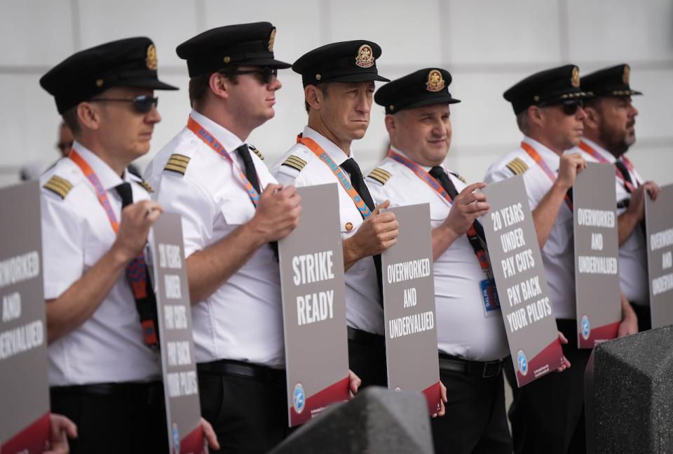 Air Canada pilots hold signs during an informational picket at Vancouver International Airport in Richmond, B.C., on Tuesday, August 27, 2024. Air Canada pilots voted overwhelmingly to approve a strike mandate last week, putting them in a position to walk off the job as early as Sept. 17. The Air Line Pilots Association, which represents more than 5,400 aviators at the country's largest carrier, said the vote passed with 98 per cent support. THE CANADIAN PRESS/Darryl Dyck