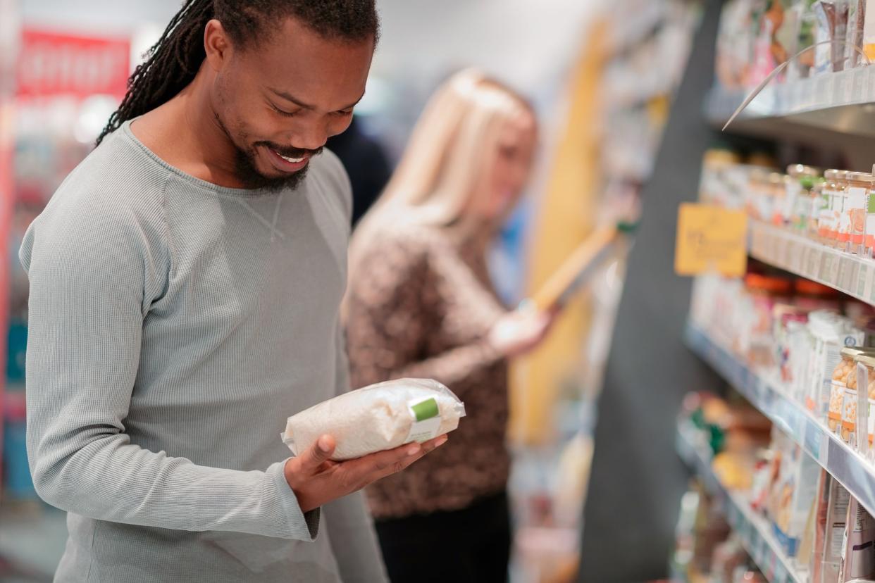 man in grocery store buying store brand rice