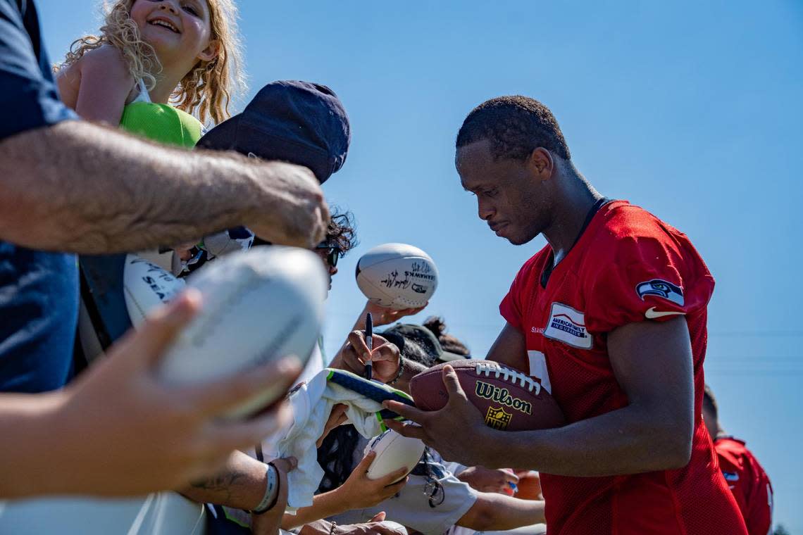 Seattle Seahawks quarterback Geno Smith signs a fan’s football after the second day of Seahawks training camp at the Virginia Mason Athletic Center in Renton, Wash. on July 28, 2022.