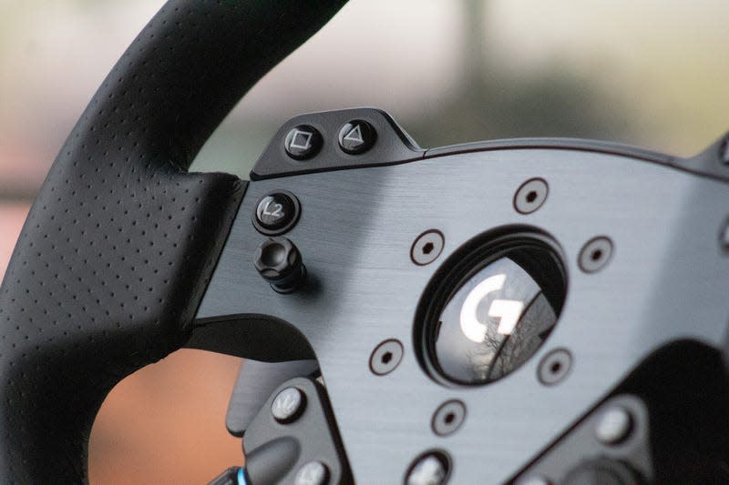 Close up on left-side controls and directional stick on Logitech G Pro steering wheel.