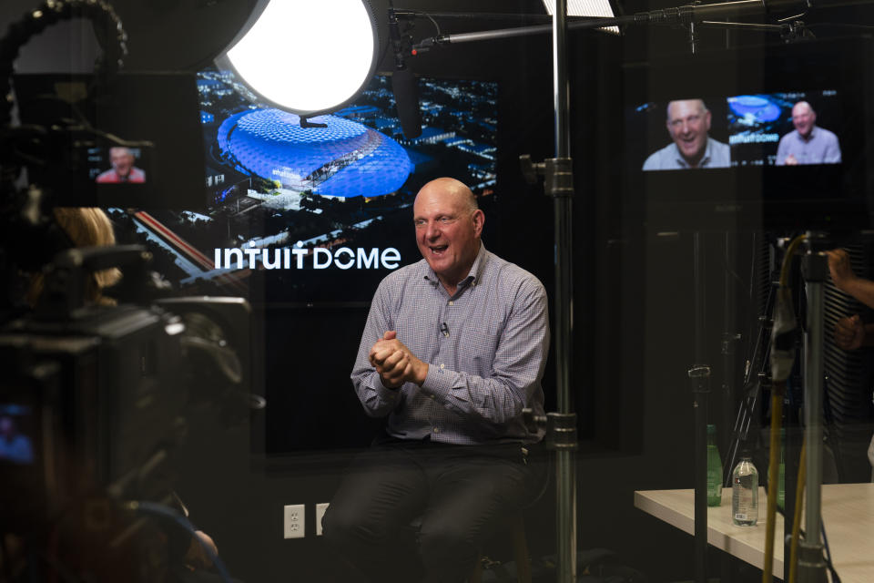 Los Angeles Clippers owner Steve Ballmer talks to a reporter during an interview as a rendering of the proposed arena for the Clippers appears on a display behind him Thursday, Sept. 16, 2021, in Los Angeles. (AP Photo/Jae C. Hong)