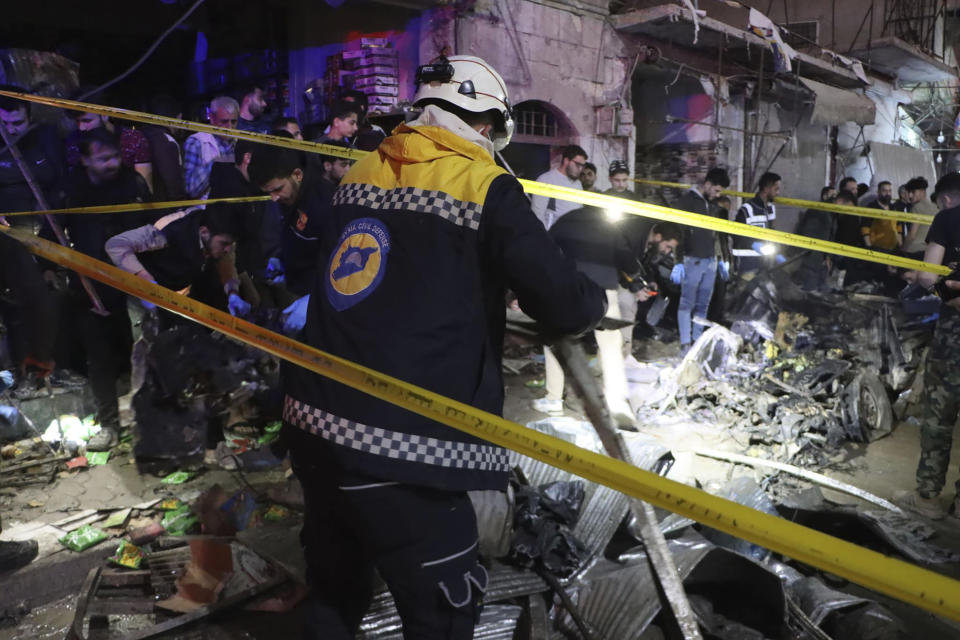 In this photo provided by the Syrian Civil Defense White Helmets, which has been authenticated based on its contents and other AP reporting, Syrian White Helmet civil defense workers search for casualties after a car bomb exploded in a busy market in the Turkish-controlled northwestern city of Azaz, Syria, early Sunday, March 31, 2024. The explosion that tore through the busy market killing at least three people and wounded five civilians, the paramedic group said, and destroyed shops and homes in the area. (Syrian Civil Defense White Helmets via AP)