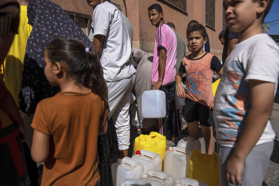 ARCHIVO - Palestinos toman agua de un grifo, en medio de una escasez de agua, en Jan Yunis, Franja de Gaza, el domingo 15 de octubre de 2023. (AP Foto/Fatima Shbair, Archivo)