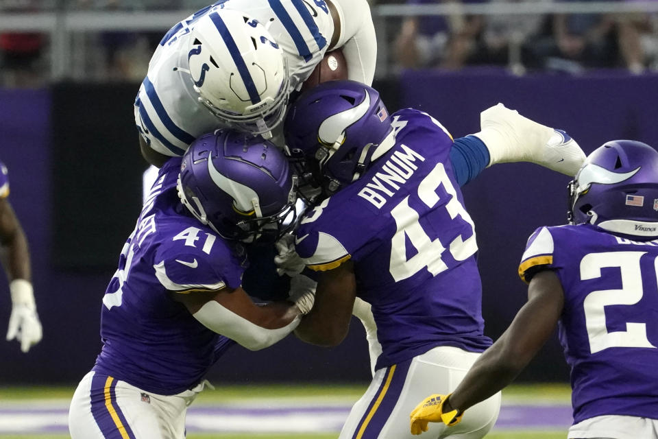 Indianapolis Colts tight end Farrod Green, center, is tackled by Minnesota Vikings linebacker Chazz Surratt, left, and cornerback Camryn Bynum, right, after catching a pass during the first half of an NFL football game, Saturday, Aug. 21, 2021, in Minneapolis. (AP Photo/Jim Mone)
