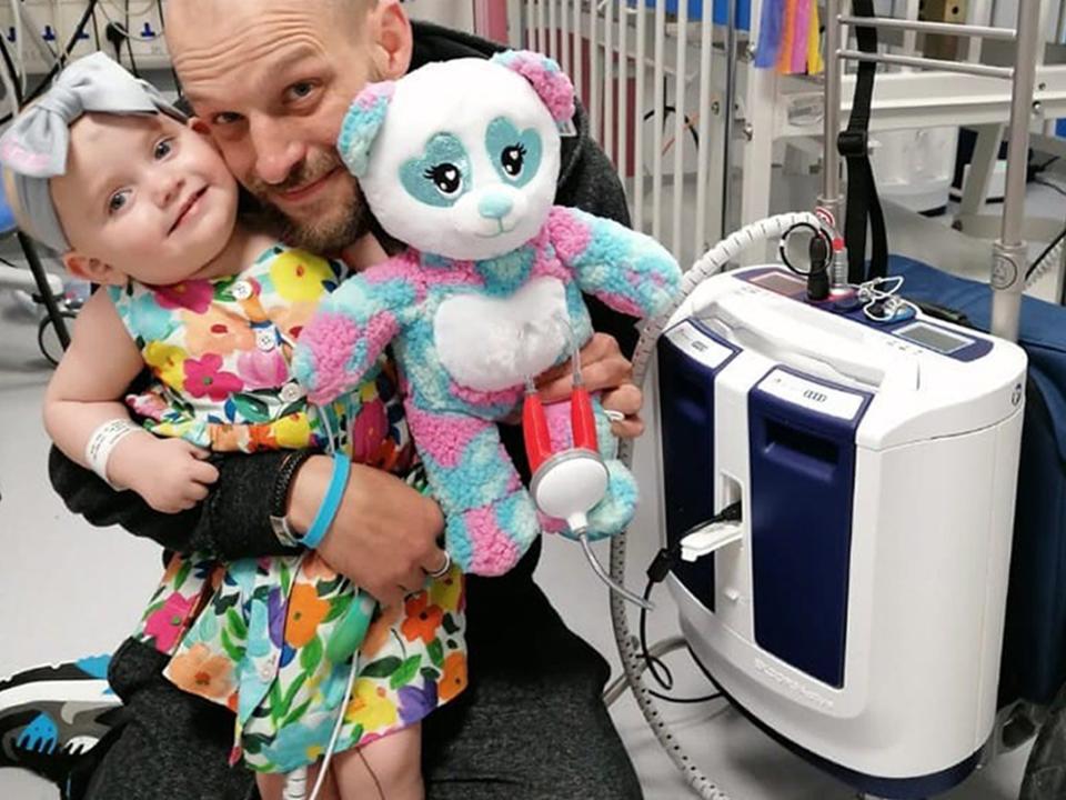 Baby Grace with father Darren and her new portable heart pump (PA)