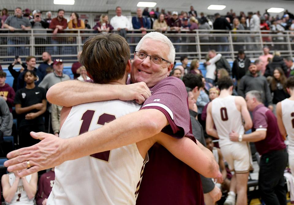 Stow head coach David Close hugs Nick Timberlake after the Bulldogs beat Jackson in a Division I Boys Basketball district final at Alliance High School on Saturday, March 4, 2023.