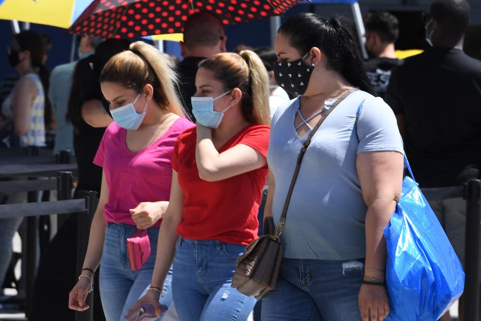 People wearing face masks wait in line to shop at Ikea in Carson, California on July 4, 2020 the US Independence Day holiday. (Photo by Robyn Beck / AFP) (Photo by ROBYN BECK/AFP via Getty Images)