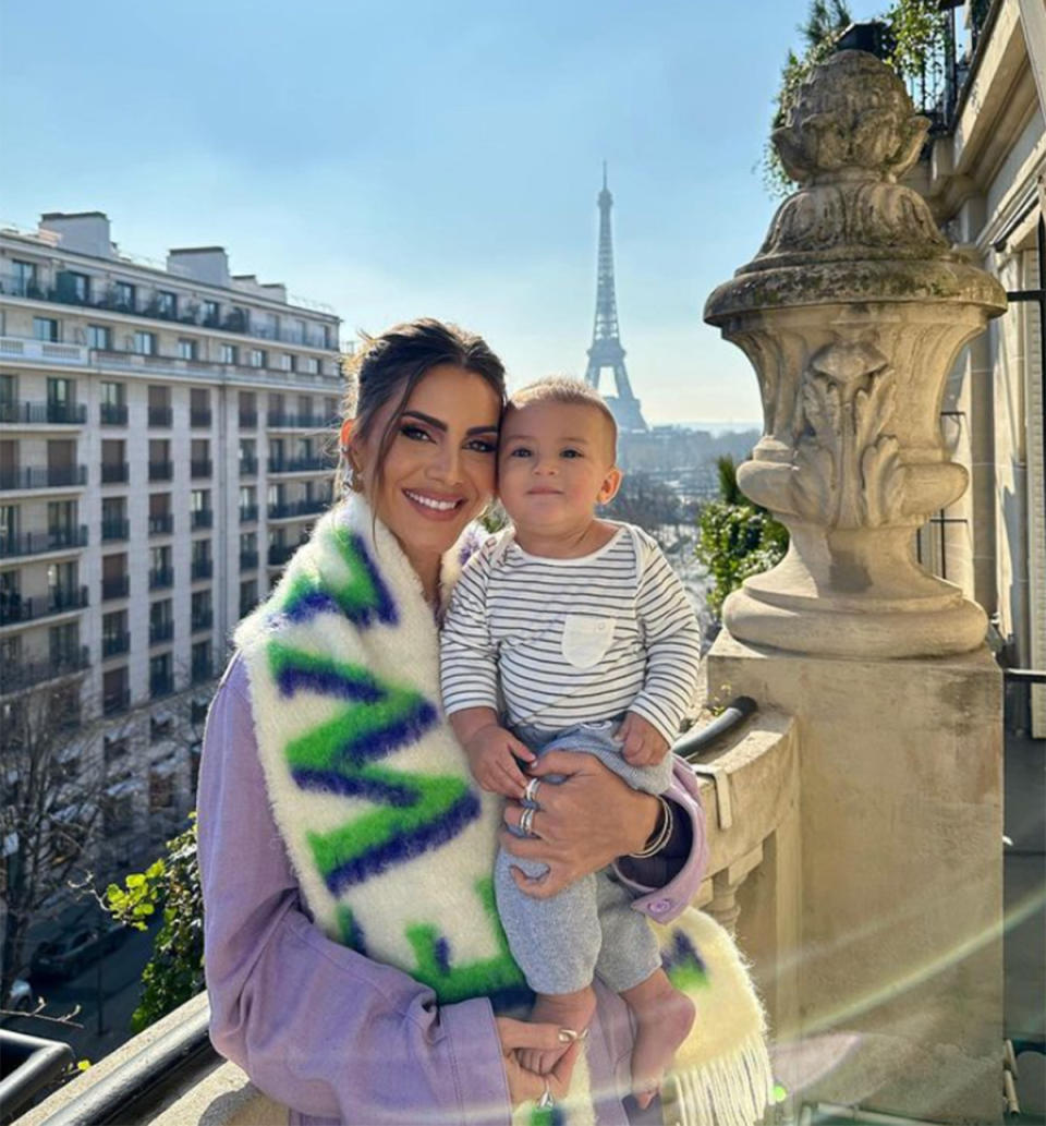 Camila Coelho in purple with her son on a Paris balcony