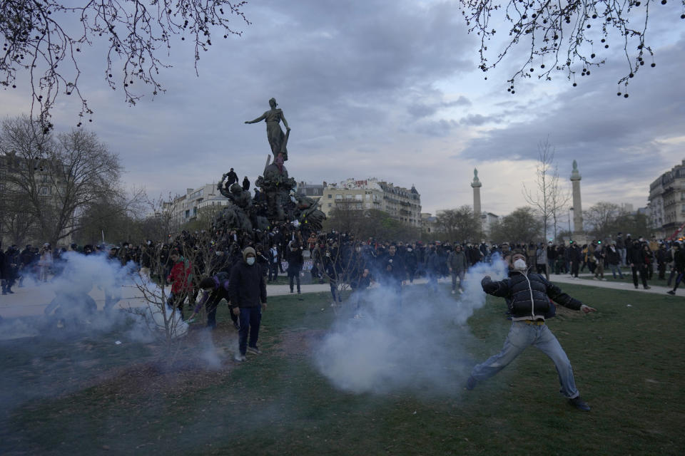 Youths throw tear gas from Place de la Nation after a demonstration Tuesday, March 28, 2023 in Paris. It's the latest round of nationwide demonstrations and strikes against unpopular pension reforms and President Emmanuel Macron's push to raise France's legal retirement age from 62 to 64. (AP Photo/Thibault Camus)