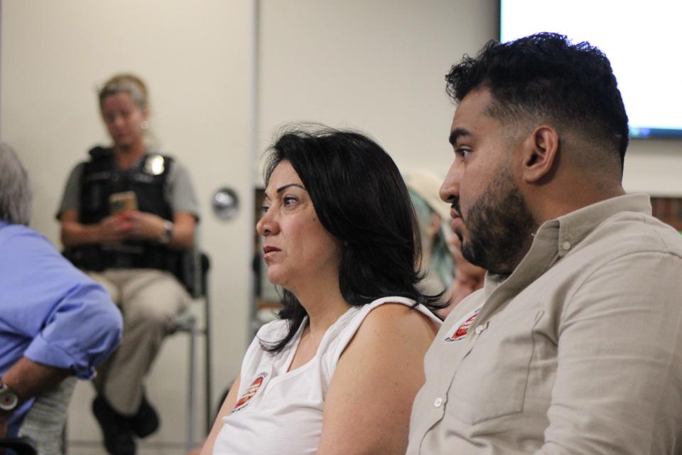 Dr. Yolo Diaz, a pediatrician, and Rogelio Contreras, a community mobilizer at Wello, listen to a Green Bay School Board meeting Monday in Green Bay. Both of them are members of the Northeast Wisconsin Latino Education Task Force.