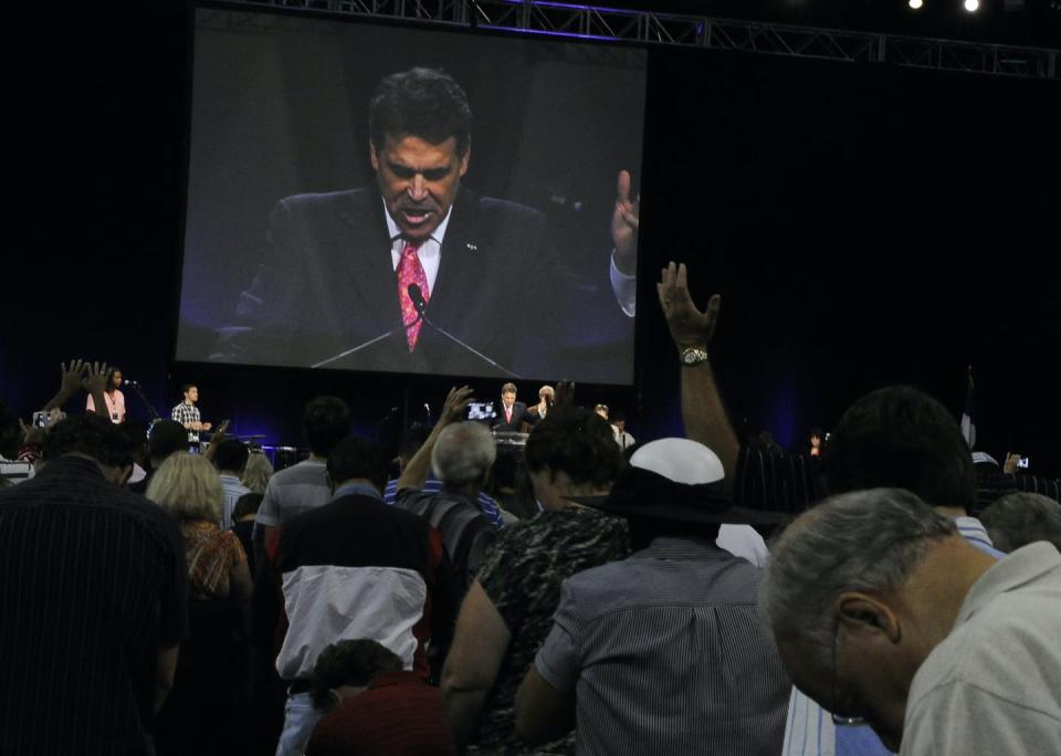 <span class="caption">Worshipers pray with Texas Gov. Rick Perry, seen at center and on screen, at The Response, a daylong prayer and fast rally on Aug. 6, 2011, at Reliant Stadium in Houston.</span> <span class="attribution"><span class="source">AP Photo/Pat Sullivan</span></span>