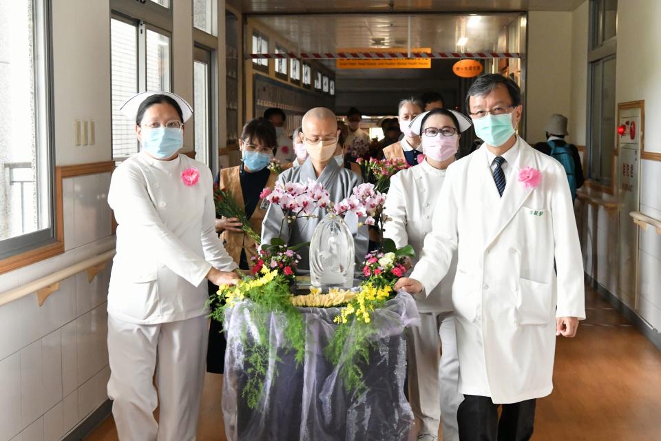 德璔師父、醫務秘書李毅與護理同仁、志工推著行動浴佛車前往合心六樓病房。