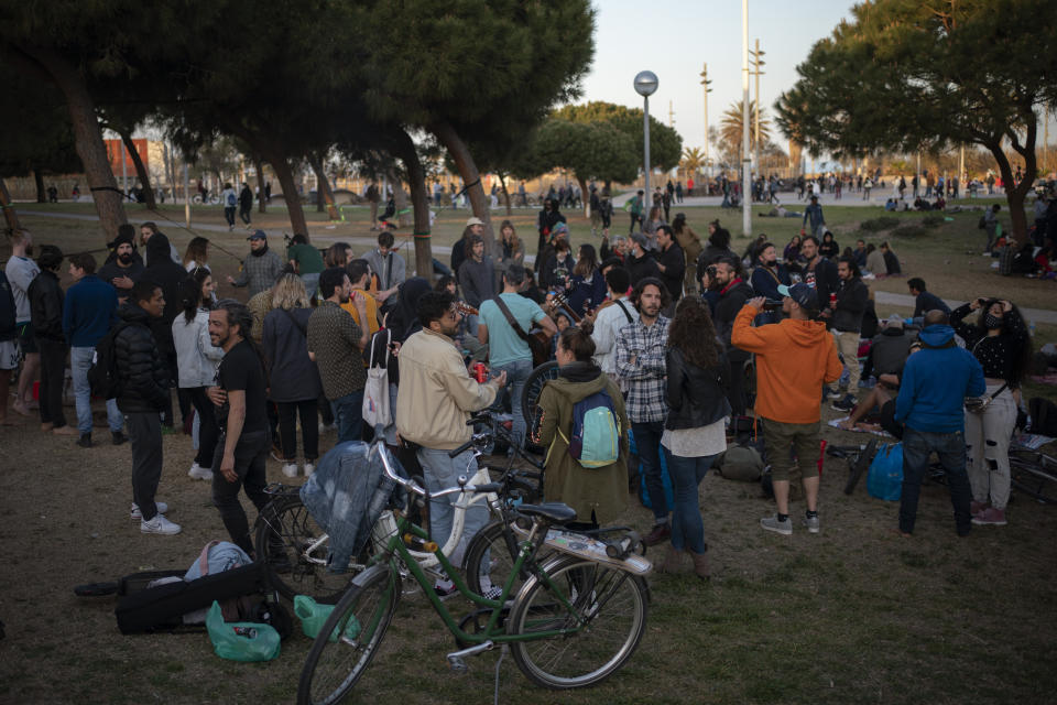 Local people gather at a public park in Barcelona, Spain, Sunday, March 28, 2021. Efforts in Spain to restart tourism activity is drawing a mixed picture due to a patchwork of national, regional and European rules on travel that is confusing both tourists and their hosts. (AP Photo/Emilio Morenatti)