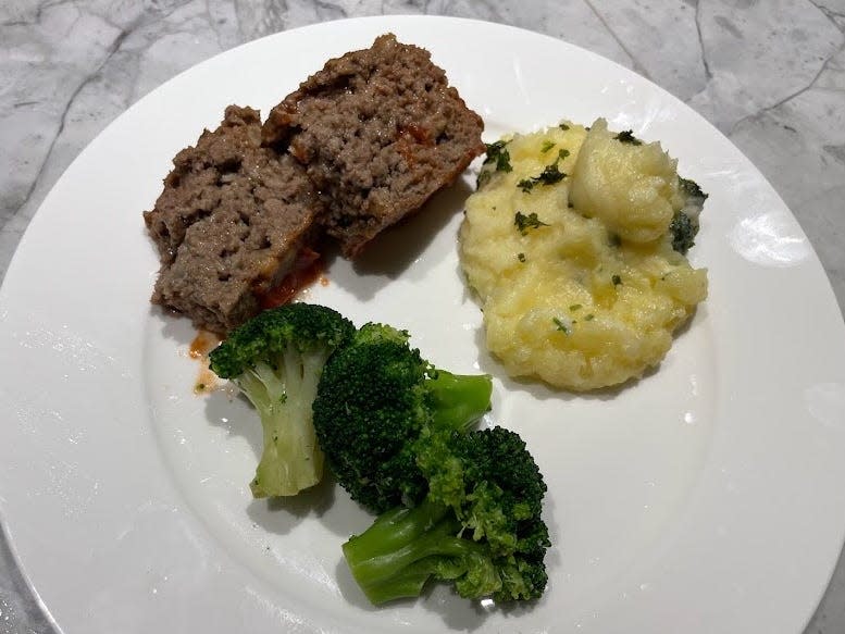 Prepared meatloaf and mashed potatoes on a plate with broccoli