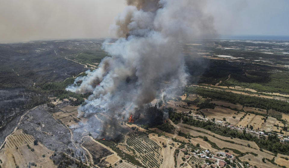 An aerial photo shows wildfires in Kacarlar village near the Mediterranean coastal town of Manavgat, Antalya, Turkey, Saturday, July 31, 2021. The death toll from wildfires raging in Turkey's Mediterranean towns rose to six Saturday after two forest workers were killed, the country's health minister said. Fires across Turkey since Wednesday burned down forests, encroaching on villages and tourist destinations and forcing people to evacuate. (AP Photo)