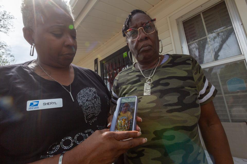 Sheryl Tyree, left and Desiree Miles show a photo of 5-year-old Zoey Felix as they stand on Miles' porch Tuesday. The two had helped Zoey clean up and fixed her hair earlier this year when this photo was taken.