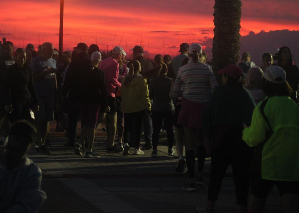 Runners watch the sunrise at SeaWalk Pavilion minutes before the start of Sunday's Donna Marathon in Jacksonville Beach.