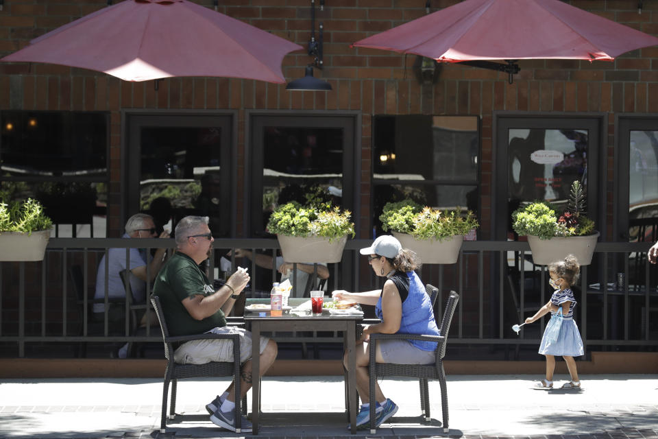 FILE - In this July 18, 2020 file photo patrons eat at table set up on a sidewalk in Burbank, Calif. A steady drop in coronavirus cases across California cleared the way Tuesday, Sept. 22, 2020, for the wider reopening of businesses in nine counties, including much of the Bay Area, the state said. (AP Photo/Marcio Jose Sanchez,File)