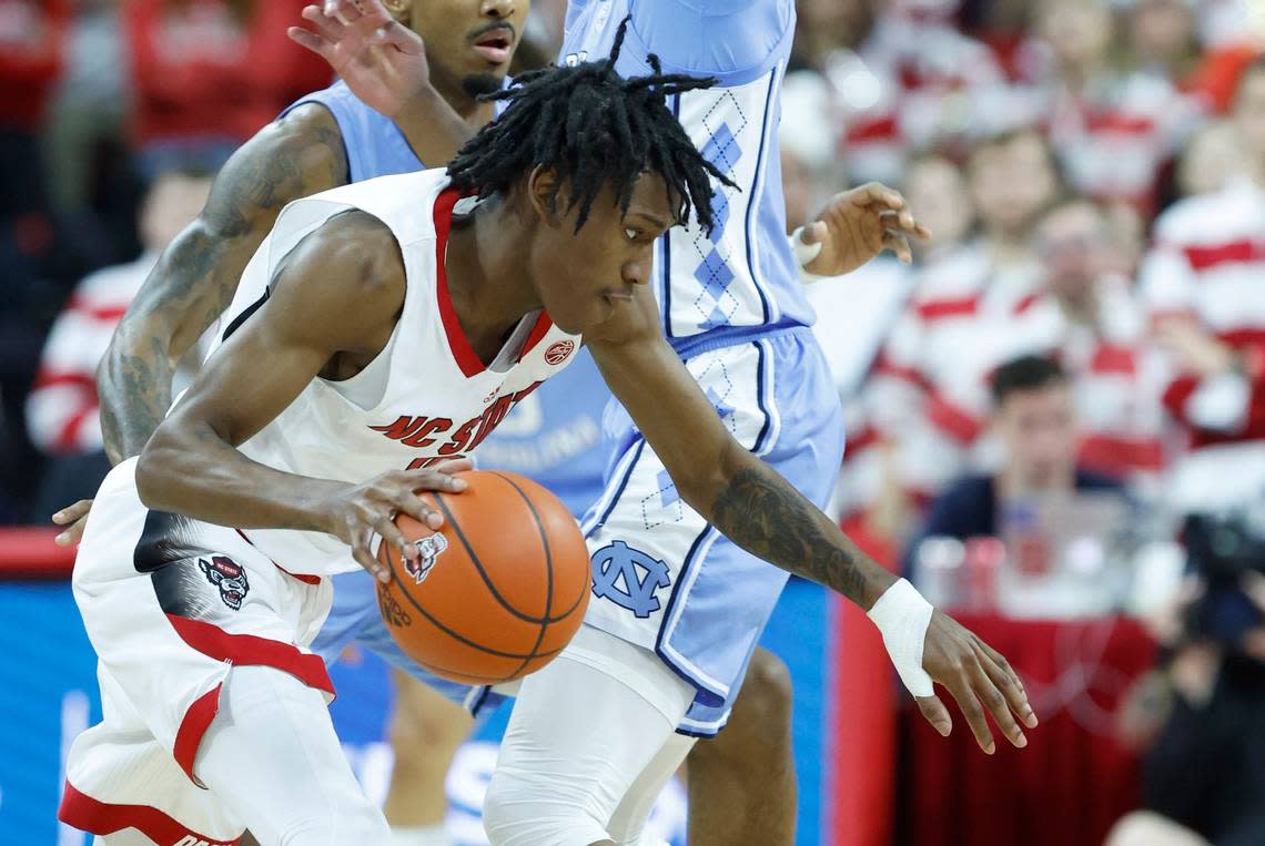 N.C. State’s Terquavion Smith (0) drives by North Carolina’s Puff Johnson (14) during the first half of N.C. State’s game against UNC at PNC Arena in Raleigh, N.C., Sunday, Feb. 19, 2023.
