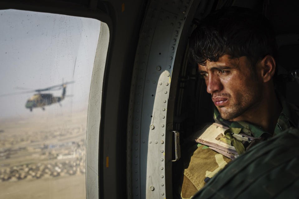 2021年5月6日，阿富汗城市坎大哈，一名士兵在一輛進行補給任務的UH-60黑鷹直升機向窗外望。