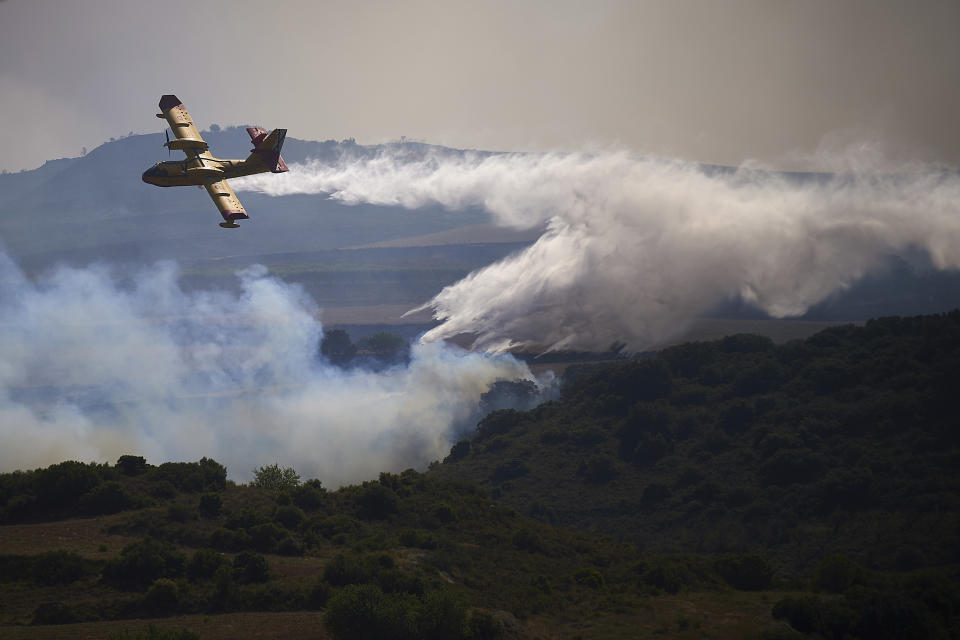 FILE, A firefighter plane drops a fire retardant on a burning area of San Martin de Unx in northern Spain, Sunday, June 19, 2022. Spain is breathing a sigh of relief as a sharp drop in temperatures is helping firefighters contain wildfires across the country that destroyed tens of thousands of acres of wooded land. But it's still only June. Extended drought conditions in several Mediterranean countries, a heat wave last week that reached northern Germany and high fuel costs needed to operate firefighting aircraft have already heightened concerns across Europe this summer. (AP Photo/Miguel Oses, File)