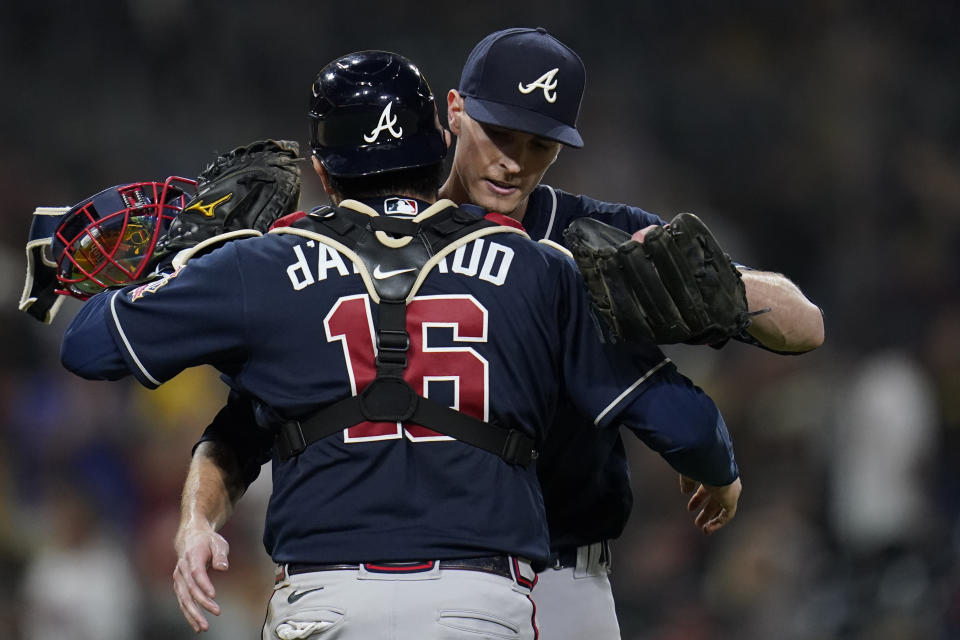 Atlanta Braves starting pitcher Max Fried, right, celebrates with catcher Travis d'Arnaud after throwing a complete game as the Braves defeated the San Diego Padres 4-0 in the baseball game Friday, Sept. 24, 2021, in San Diego. (AP Photo/Gregory Bull)