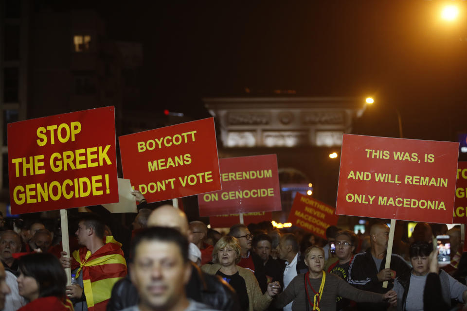 Supporters of a movement for voters to boycott the referendum, hold placards as they celebrate in central Skopje, Macedonia, after election officials gave low turnout figures, Sunday, Sept. 30, 2018. The crucial referendum on accepting a deal with Greece to change the country's name to North Macedonia to pave the way for NATO membership attracted tepid voter participation Sunday, a blow to Prime Minister Zoran Zaev's hopes for a strong message of support. (AP Photo/Thanassis Stavrakis)