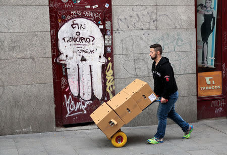 A man pushes a cart loaded with boxes in Madrid, Spain, December 2, 2016. REUTERS/Andrea Comas