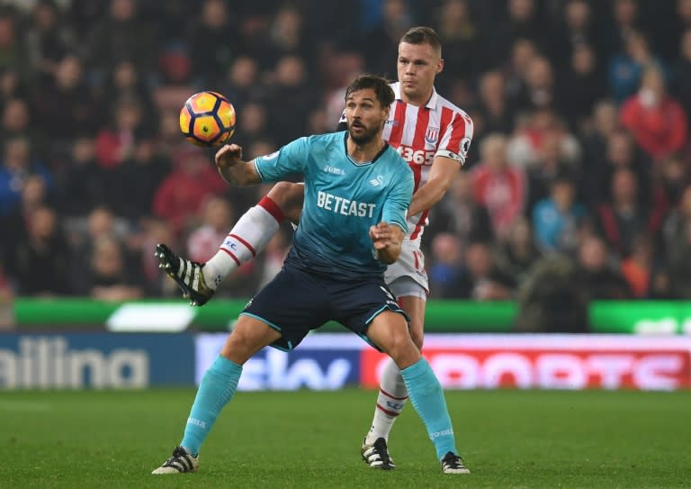 Swansea City's striker Fernando Llorente (L) vies with Stoke City's defender Ryan Shawcross during the English Premier League football match October 31, 2016