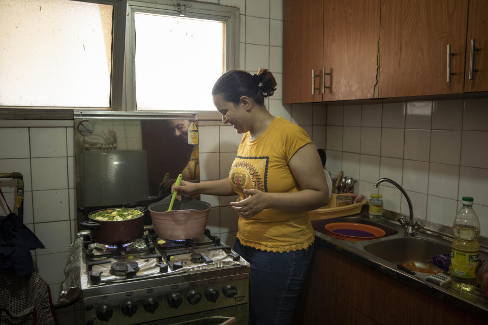 Fatma Youssef, a volunteer part of an initiative that sends meals to quarantined coronavirus patients, cooks a meal for a family, in her apartment, in Cairo, Egypt, Saturday, July 11, 2020. She and other volunteers in Egypt hope the meals will help nurse quarantined coronavirus patients back to health and provide them with some respite. In different neighborhoods in Cairo and some other cities they've enlisted people to cook, donate food or make contactless deliveries to patients' homes. (AP Photo/Nariman El-Mofty)