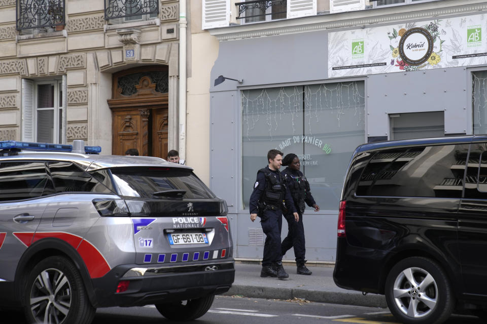 A police car and a hearse park outside Jane Birkin's home Sunday, July 16, 2023 in Paris. Actress and singer Jane Birkin, who charmed France with her English grace, natural style and accented French and made the country her home, has died Sunday at age 76. (AP Photo/Christophe Ena)