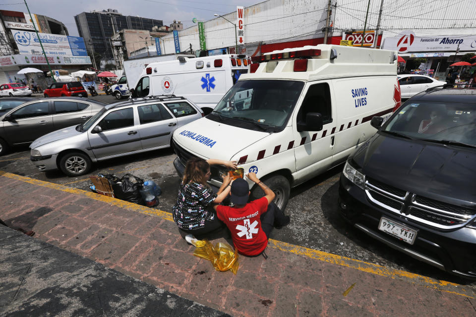 Dos personas reparan una "ambulancia pirata" en las afueras del Hospital General de la Ciudad de México el 12 de septiembre del 2020. (AP Photo/Marco Ugarte)