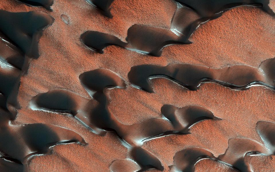 <p>Der “Mars Reconnaissance Orbiter” lieferte diese Aufnahmen von Dünen in blassem Rot, an deren Rändern teilweise noch Eisblöcke zu sehen sind. Diese Eisblöcke schmelzen, wenn es Sommer wird. (Bild: NASA/JPL-Caltech/Univ. of Arizona) </p>