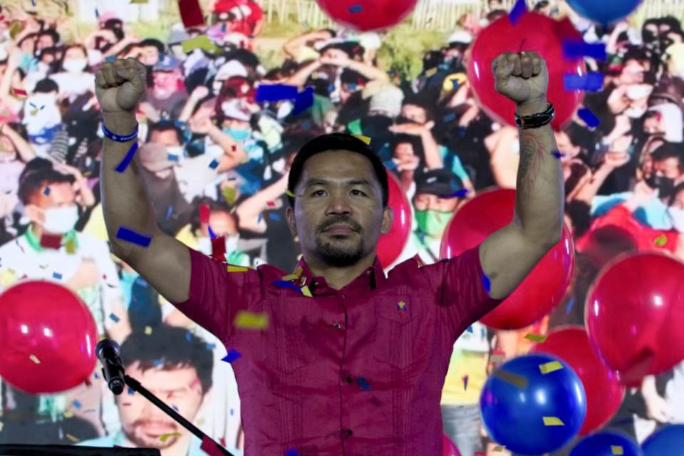 In this photo provided by the Manny Pacquiao MediaComms, Senator Manny Pacquiao raises his hands during a national convention of his PDP-Laban party in Quezon city, Philippines on Sunday Sept. 19, 2021.