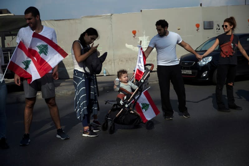 A baby and his parents take part in a human chain organised by demonstrators during ongoing anti-government protests in Beirut